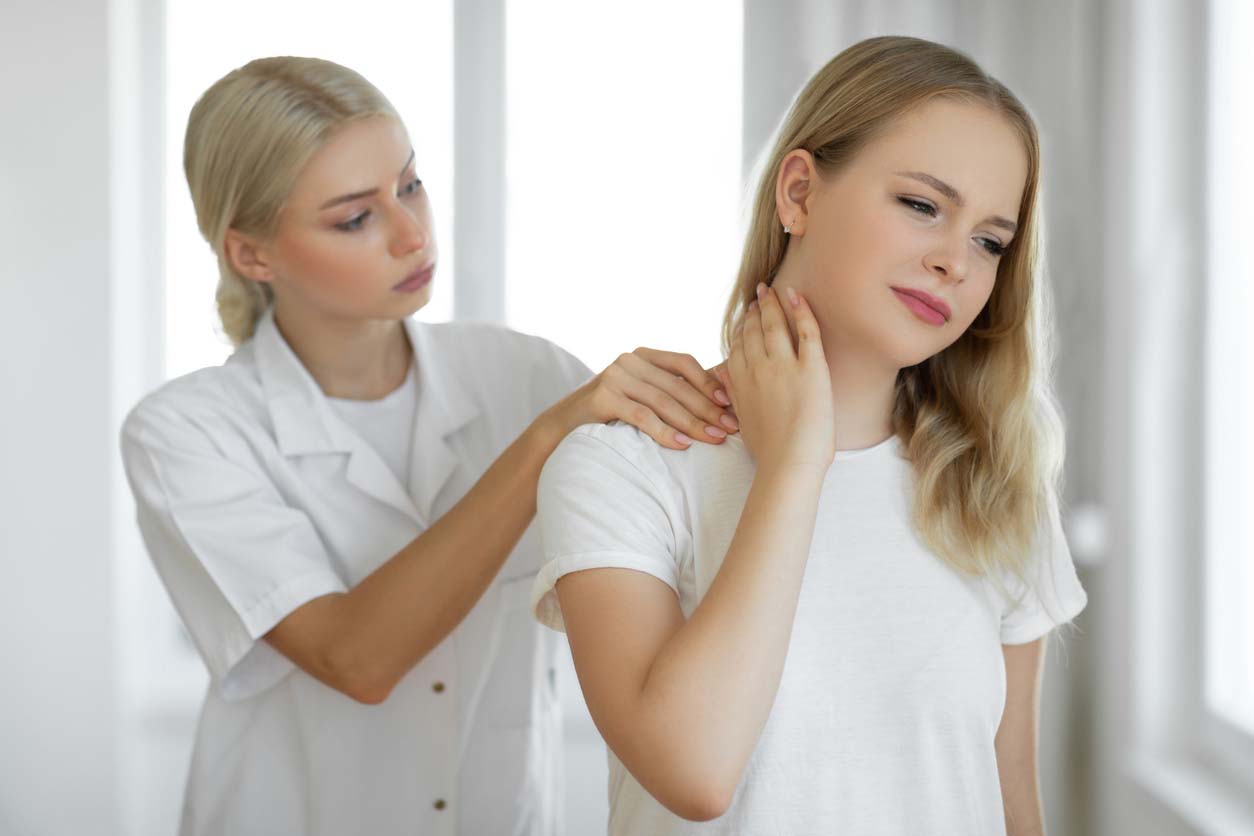 Chiropractor examining a patient with neck pain